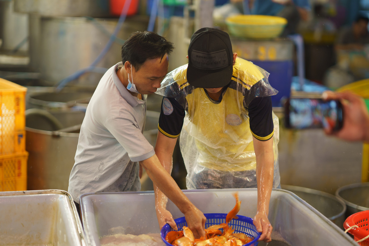 Anh Hùng (bên trái), một tiểu thương ở chợ Tân Lập (TP.Thủ Đức) cho biết, mỗi năm đều đến đây sớm hơn một ngày để nhập hàng về bán. "Hôm nay nhập trước 10kg bao gồm cá chép to và nhỏ. Nếu tín hiệu kinh doanh tốt, tôi sẽ nhập thêm vào ngày mai", anh Hùng nói.