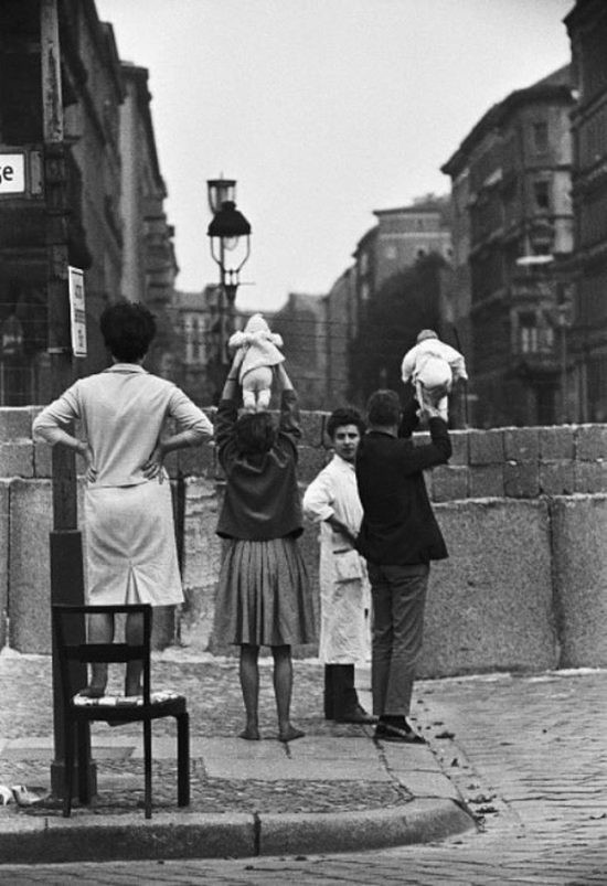 Những người dân ở Tây Berlin giơ cao những đứa trẻ lên để cha mẹ chúng ở Đông Berlin có thể thấy con mình vào năm 1961.