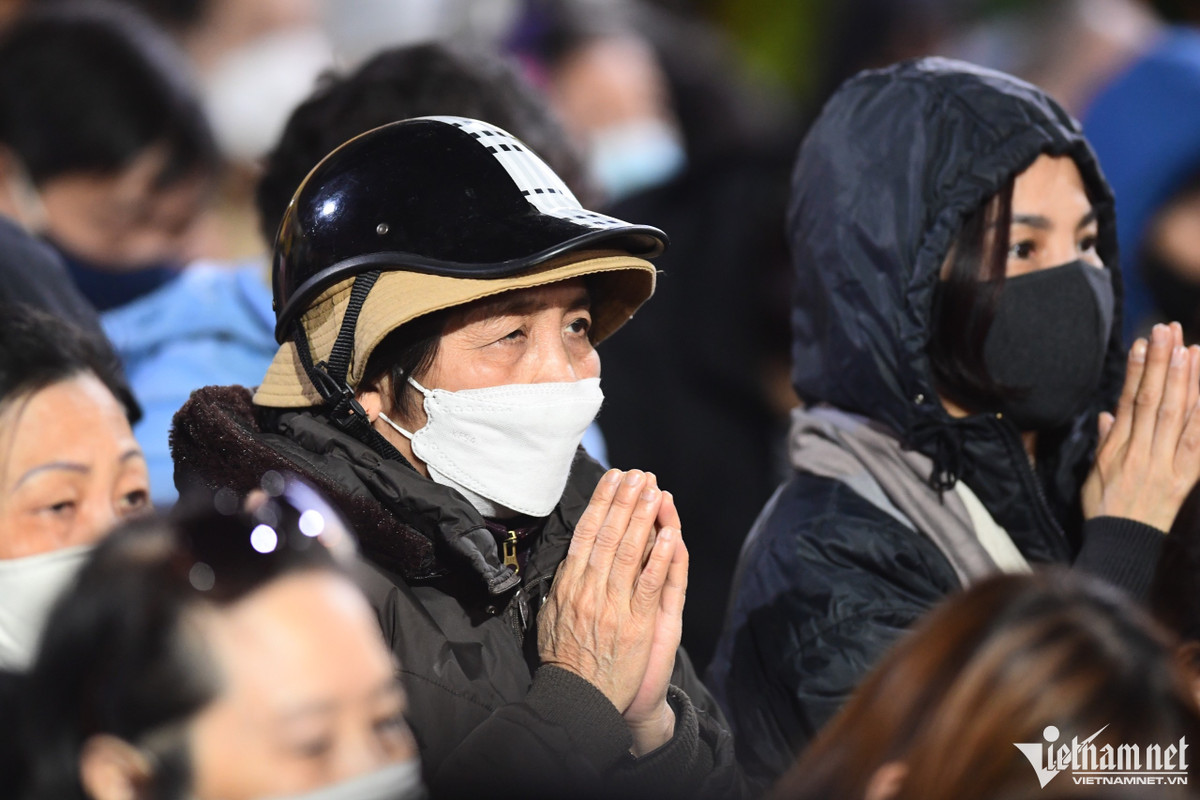 Thời tiết chuyển lạnh, gió to nhiều người phải trùm kín áo hoặc đứng sát vào nhau để nghe sư thầy tụng kinh.