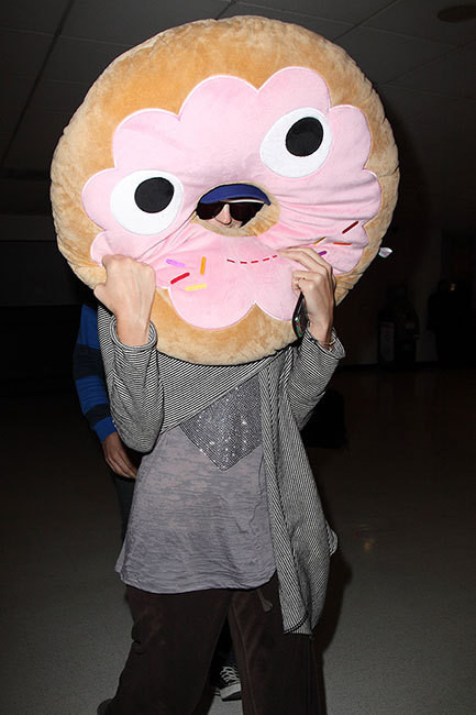 Nữ ca sĩ Katy Perry che mình sau chiếc gối dễ thương hình chiếc bánh để tránh ống kính của Paparazzi.