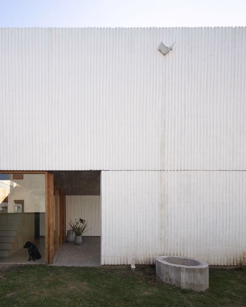 Các bức tường điều chỉnh sự riêng tư theo ranh giới, tạo ra cảnh quan đặc trưng bởi gạch sơn trắng.