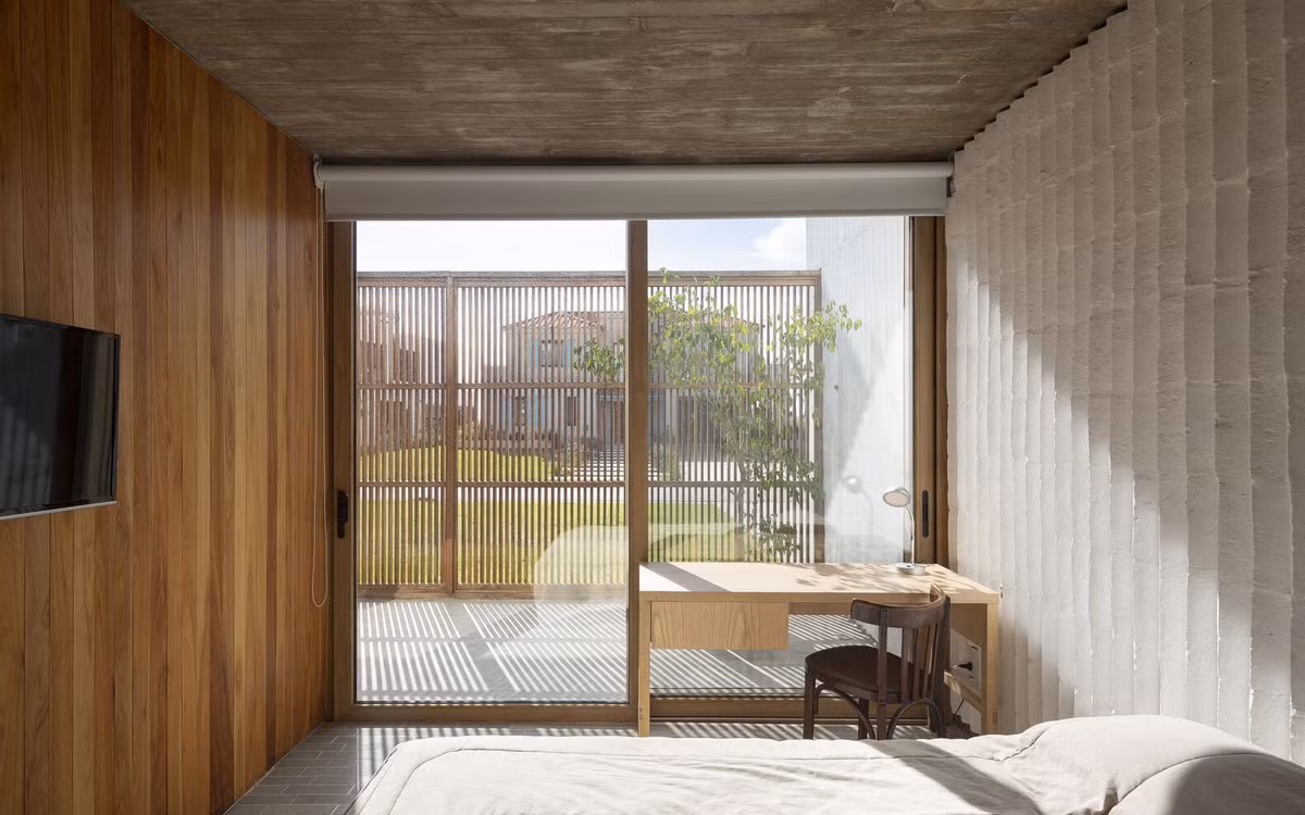 Các phòng ngủ thông thoáng nhờ cửa sổ bằng kính trong suốt. Để đảm bảo sự riêng tư, kiến trúc sư bố trí thêm rèm che có thể kéo lên hạ xuống.