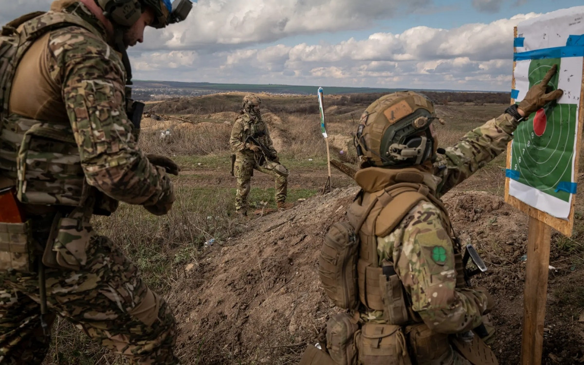 Mriya, 28 tuổi (phía sau) và Rys, 28 tuổi kiểm tra khu vực bia bắn trên thao trường.