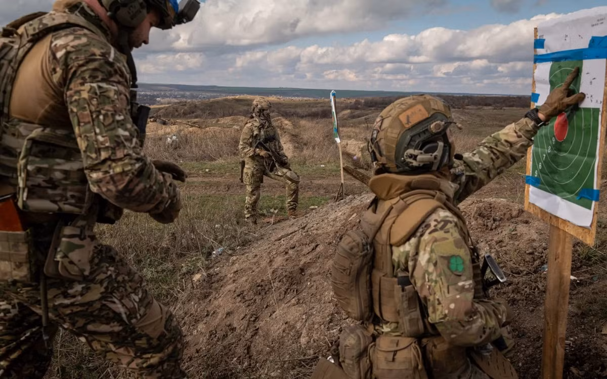 Mriya, 28 tuổi (phía sau) và Rys, 28 tuổi kiểm tra khu vực bia bắn trên thao trường.