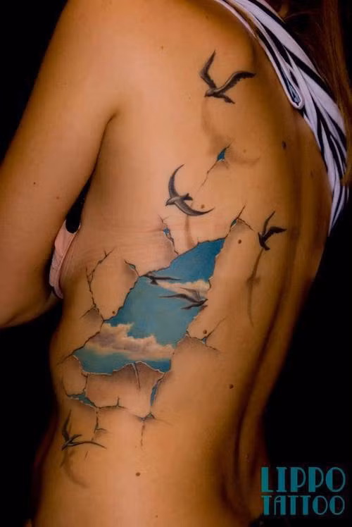 Khoảng trời xanh, mây trắng và chim bay lộ ra đằng sau một mảng cơ thể bị bong tróc.