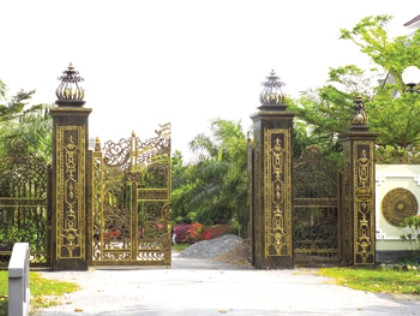 Những căn nhà gỗ thuộc nhóm gỗ đặc biệt không dùng đến một cái đinh sắt. Nguồn tin từ một số cán bộ ở TTCP và cán bộ ở Bến Tre, ông Truyền còn có 3 cơ ngơi ở TP Hồ Chí Minh là phường Thảo Điền (Quận 2), ở Quận 5, ở khu đô thị “5 sao” Phú Mỹ Hưng do người thân đang quản lí, sử dụng. Người ta còn đồn rằng cái giường “đặc biệt” của vợ chồng ông có giá trị nhiều tỉ đồng... Trong ảnh: Cổng chính đi vào dinh thự và “dự án gia đình” của ông Trần Văn Truyền màu sắc như sơn son thếp vàng.