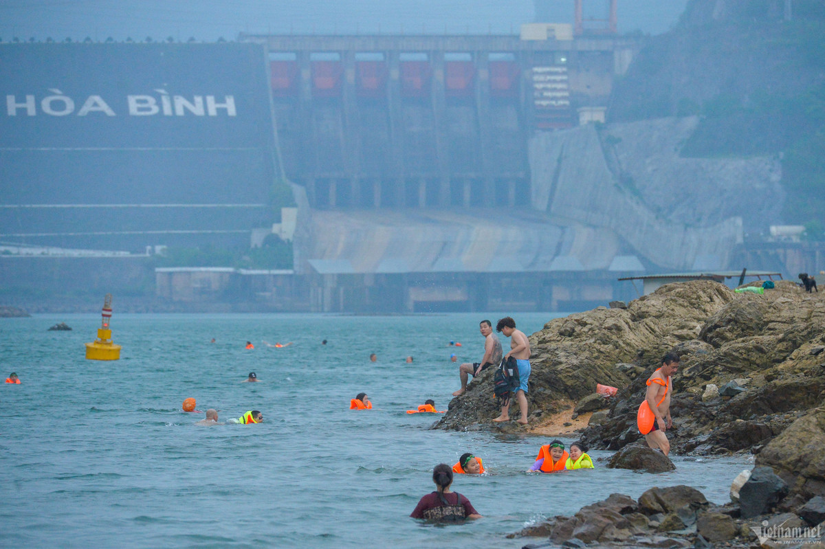 Trong khi đó, ngay phía dưới cửa đập, rất đông người tụ tập bơi lội và tắm mát dù bị cảnh báo cấm.