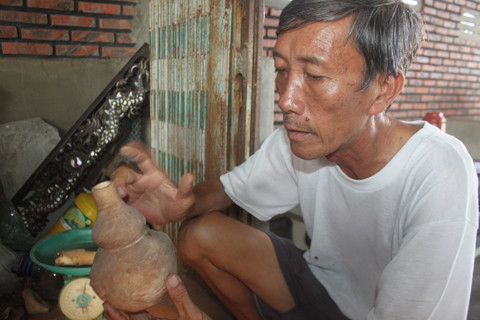 Ông Ẩn bên một bình gốm cổ.