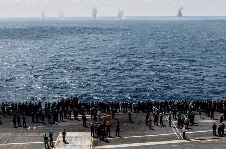 Thủy thủ và khách dân sự trên tàu sân bay USS George Washington (CVN 73) thích thú quan sát các cột nước từ đằng xa sau khi các quả đạn pháo rơi xuống mặt biển trong cuộc tập trận Tiger Cruise.