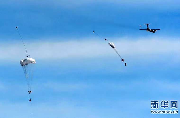 Hệ thống dù “khủng” gắn trên xe thiết giáp bắt đầu bung ra, có ít nhất 3 chiếc ZLC-2000 nhảy từ một máy bay Il-76.