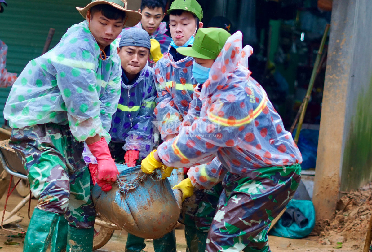 Cây gỗ, đất đá tràn xuống nhà dân được các chiến sĩ dọn dẹp.