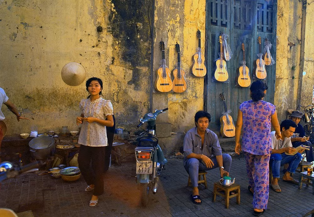 Các nam giới thưởng thức cà phê sáng trên vỉa hè.