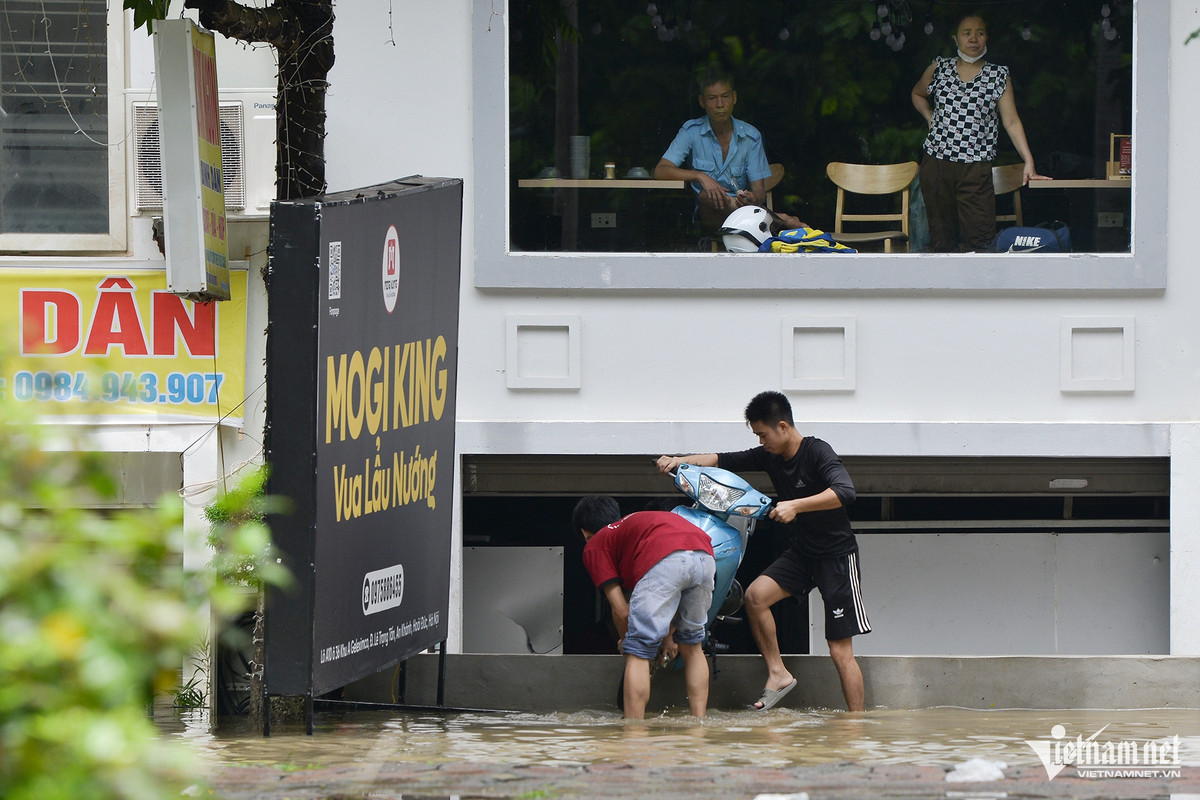 Hai thanh niên giải cứu chiếc xe máy từ trong hầm một ngôi biệt thự.