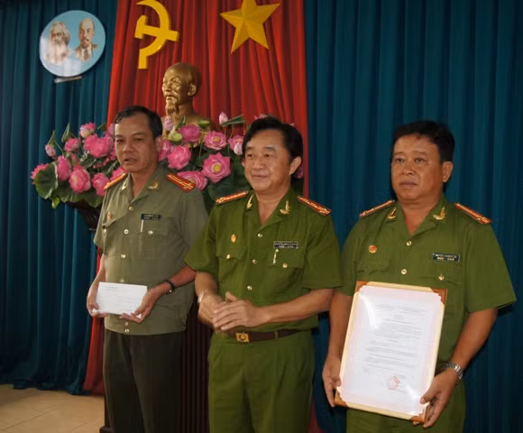 Đại tá Nguyễn Hoàng Thao, Phó GĐ Công an tỉnh Bình Dương (giữa) thưởng nóng cho đại diện ban chuyên án.