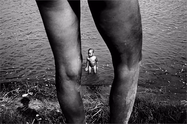 Mùi đứng bên bờ sông gọi con lên, và Phả dùng dằng không chịu. Mỗi ngày Mùi và con ở khoảng 8 giờ cạnh dòng sông nơi đã bị ô nhiễm vì nước thải của thành phố.