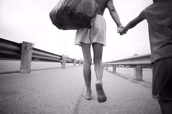 Mùi nằm tay con đi trên đường xa lộ ở Hà Nội. Phả thích nắm tay và thường với tay nắm láy tay của mẹ. Mỗi ngày hai mẹ con, chân đất, đi bộ khoảng 10 dặm đường quanh thành phố, thường là ở khu ven sông Hồng.