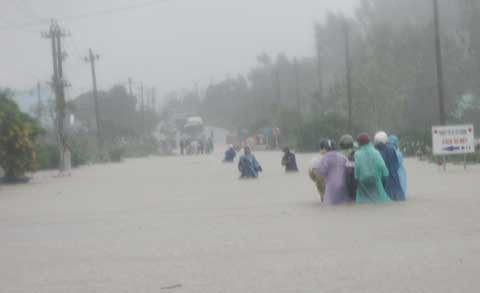 Không chờ đợi được, một số người dân liều lĩnh thuê người khiêng xe máy qua cầu. Ảnh: Báo Bình Định