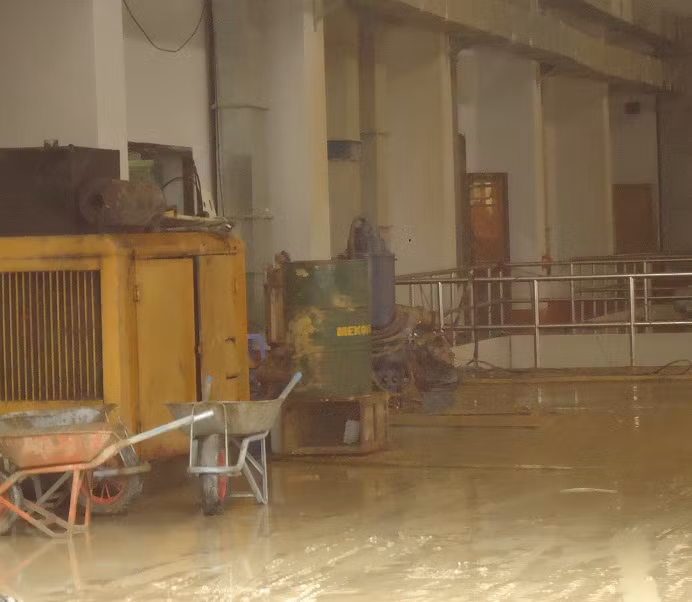 Bên trong nhà máy, lớp cát và bùn dày đặc.