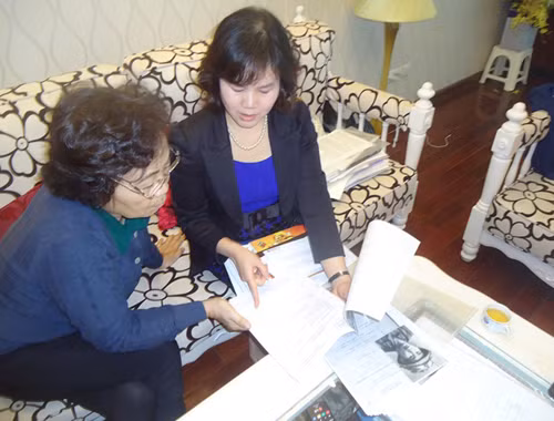 Nhà ngoại cảm Phan Thị Bích Hằng (phải) đang trao đổi về hồ sơ xét nghiệm ADN với nhà giáo Quan Lệ Lan.