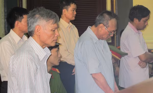 Quan tham Vũ Quốc Hảo (trái) và Đặng Văn Hai (đeo kính) cùng các bị cáo nghe tòa tuyên án.