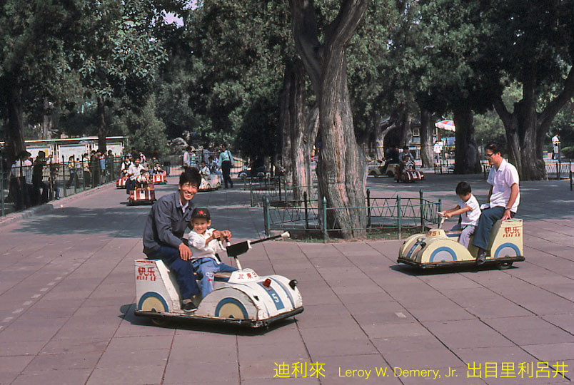 Trẻ em và người lớn vui chơi bằng xe ô điện điện ở công viên Lao Động.