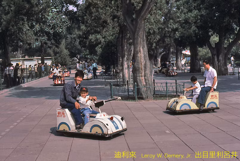 Trẻ em và người lớn vui chơi bằng xe ô điện điện ở công viên Lao Động.