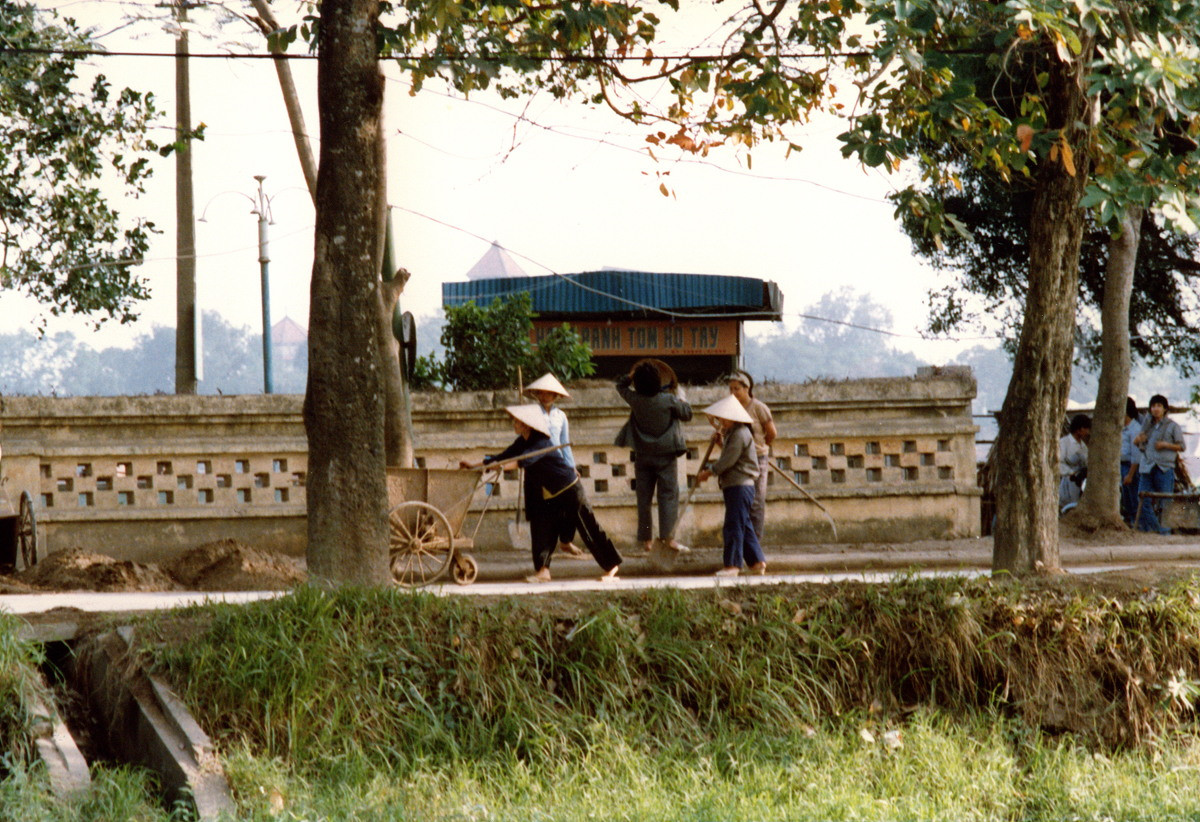 Khu vực nhà hàng bánh tôm Hồ Tây ở đường Thanh Niên, bên bờ hồ Trúc Bạch. Đỉnh tháp chuông nhà thờ Cửa Bắc thấp thoáng phía xa.