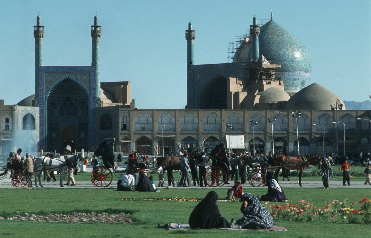 Người dân thư giãn trên bãi cỏ bê ngoài thánh đường Shah ở Isfahan. Công trình này hoàn thành năm 1629, ngày nay là một Di sản văn hóa thế giới.