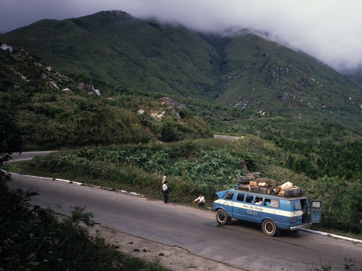 Chiếc xe buýt chạy tuyến Huế - Đà Nẵng trên đèo Hải Vân, nhìn từ cửa sổ toa tàu.
