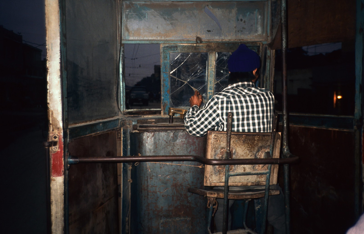 Người lái tàu trong ca-bin toa tàu điện cũ kỹ.