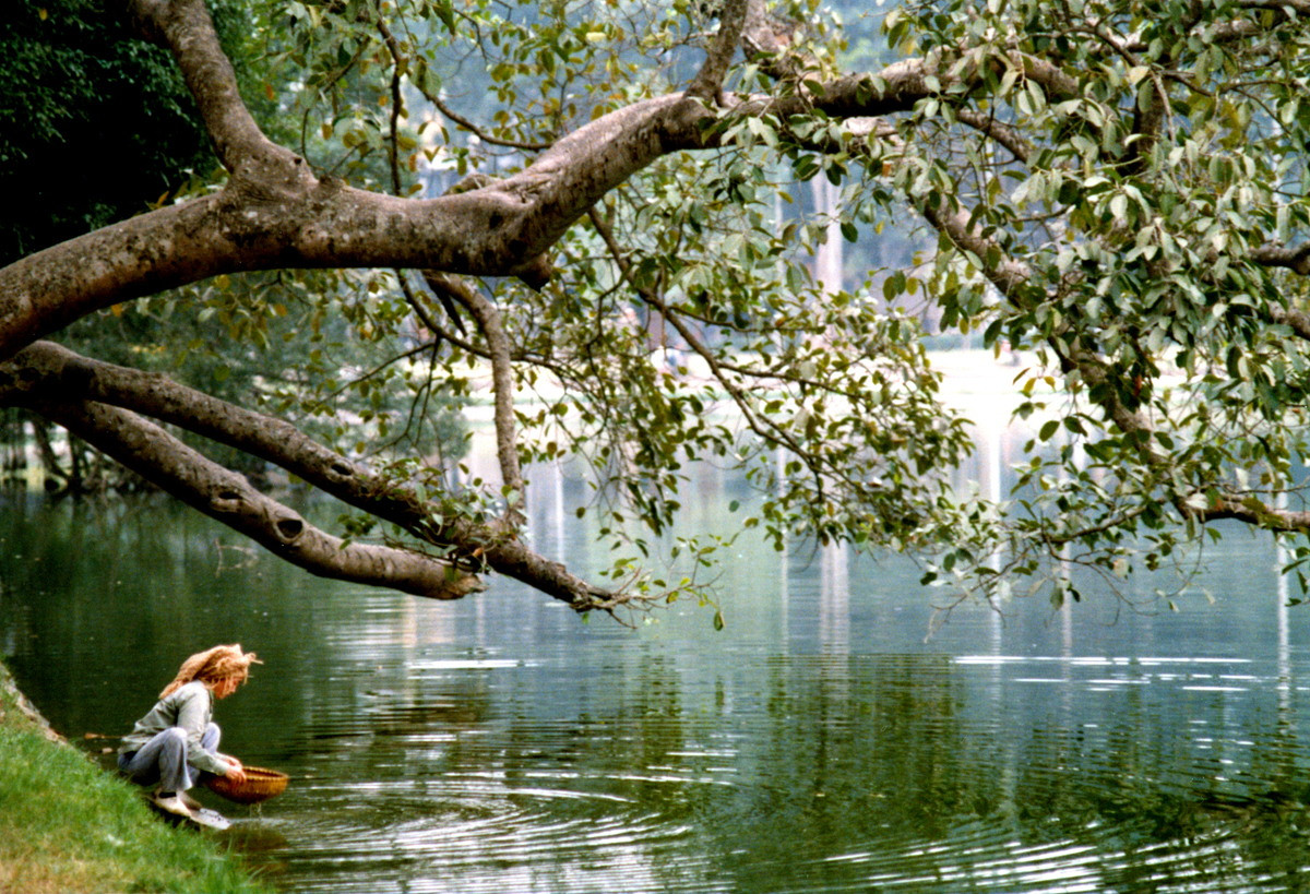 Một người phụ nữ rửa rau (?) trên mặt hồ.