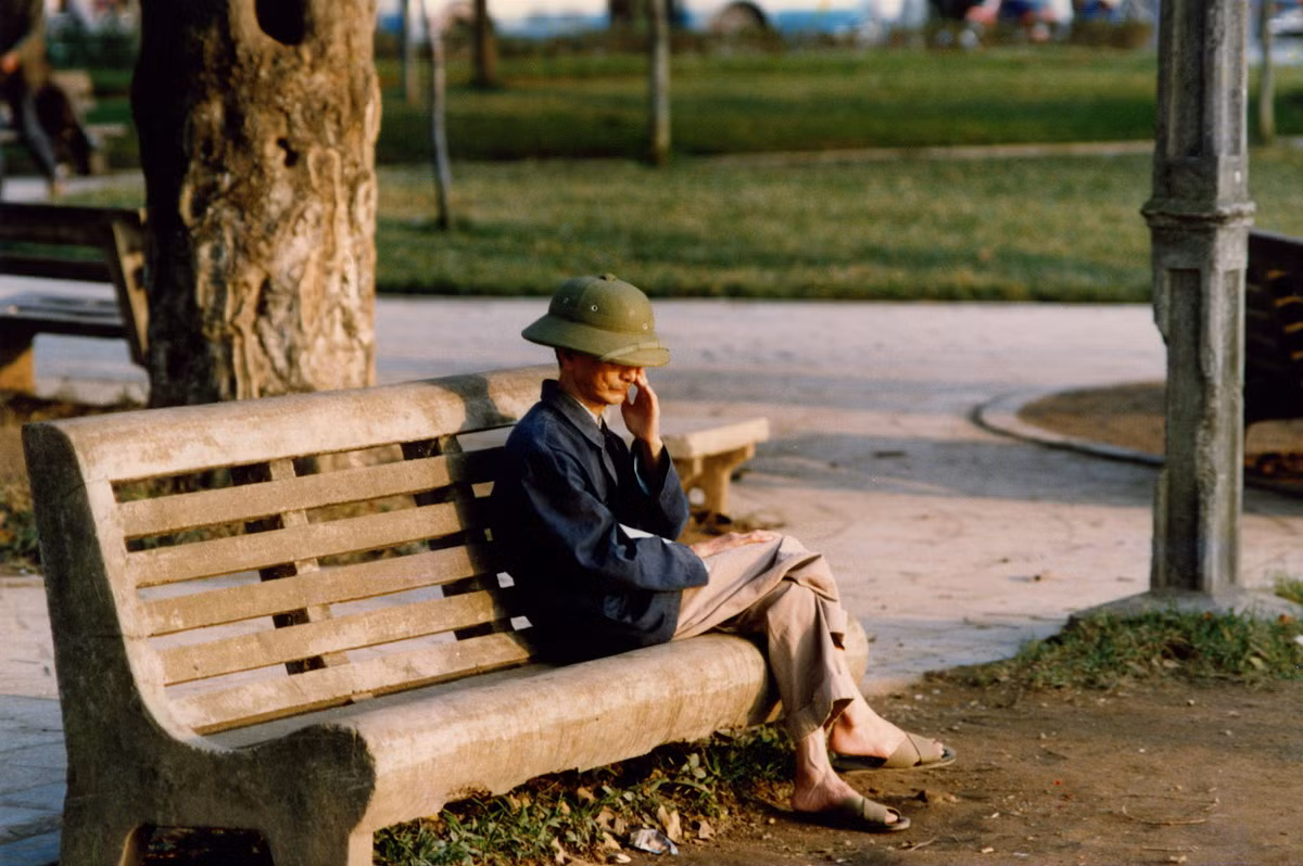 Cụ ông trầm tư bên hồ nước xanh.