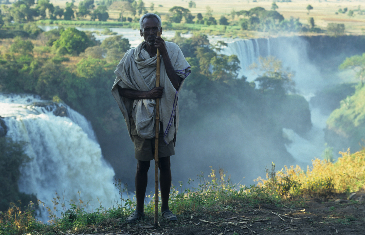 Người đàn ông bản địa đứng bên thác Tissisat, thắng cảnh nổi tiếng Ethiopia. Thác nằm ở thượng nguồn sông Nile Xanh, cách Bahir Dar và Hồ Tana khoảng 30 km về phía hạ lưu.