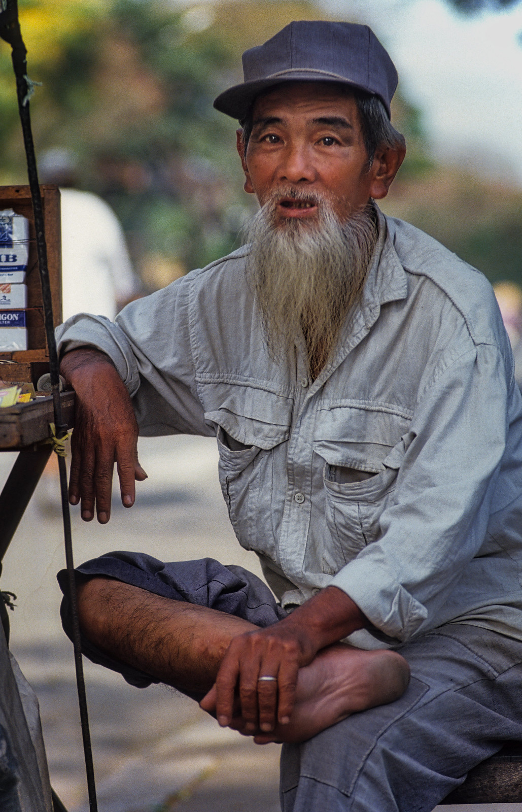 Cụ ông bán thuốc lá dạo bên lề đường.
