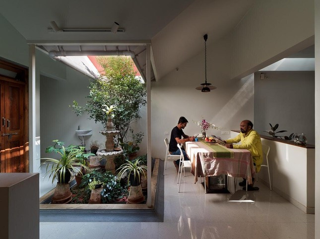 Một mặt của phòng khách có tầm nhìn vào phần sảnh của ngôi nhà qua cửa sổ và mặt kia biến thành nửa bức tường nhìn ra khu vực ăn uống và khu vườn bên ngoài.