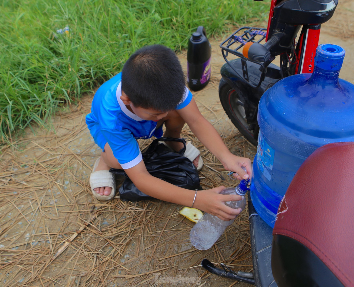 Không chỉ người lớn mà nhiều em nhỏ cũng chở cả can nước ra đồng bắt dế vào mùa này.
