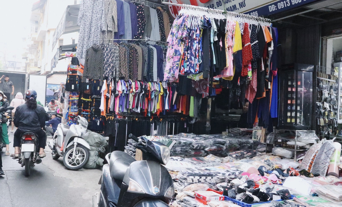 Nhiều dãy quần áo, bàn ghế, xe máy… dàn trải, phong tỏa tất cả ngõ ngách vỉa hè khiến người đi bộ không còn lối thoát.