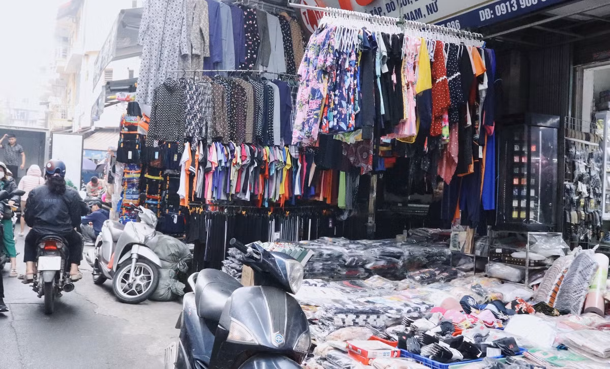 Nhiều dãy quần áo, bàn ghế, xe máy… dàn trải, phong tỏa tất cả ngõ ngách vỉa hè khiến người đi bộ không còn lối thoát.