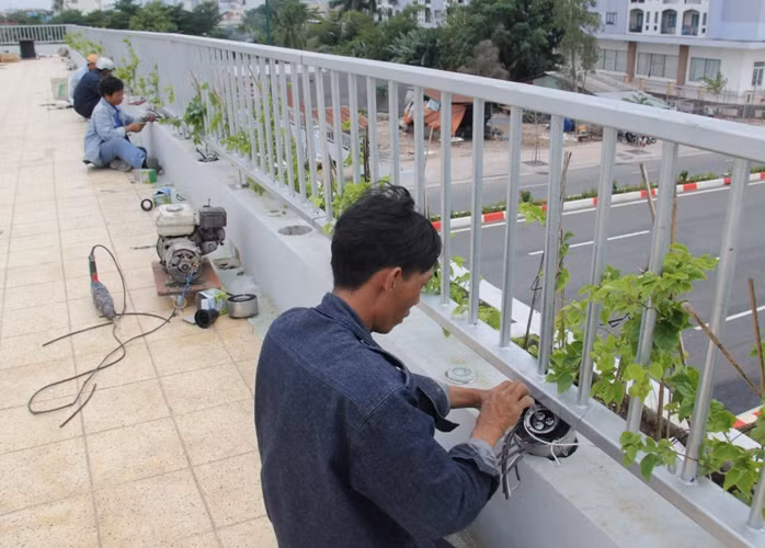 Công nhân đang gấp rút lắp đặt hệ thống đèn Led cho các cầu vượt bộ hành băng ngang đường