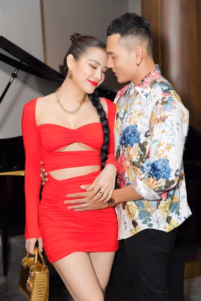 Bà bầu lựa chọn thiết kế đỏ rực với những đường cut-out khá táo bạo, khoe cả vòng 1 lẫn vòng eo.