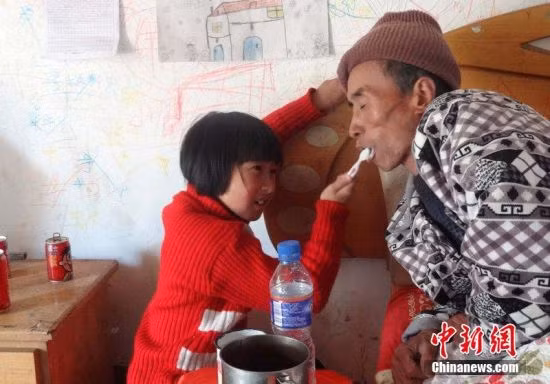 Bé Wang Jinhong bón cháo cho cha. Thậm chí, giờ đây, mọi sinh hoạt hàng ngày của ông đều phụ thuộc vào cô con gái bé bỏng. Hoàn cảnh của cô bé Wang Jinhong đã được chia sẻ trên báo chí và nhiều diễn đàn khiến dân mạng Trung Quốc đã rớt nước mắt vì cảm thương và cảm phục.