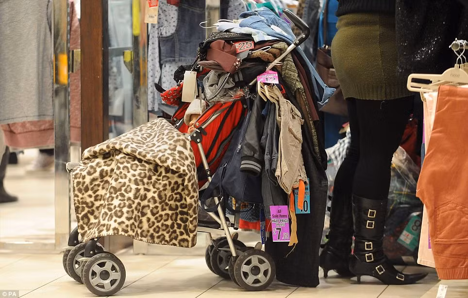 Một phụ nữ chất đồng quần áo đầy chiếc xe nôi - nơi cậu con trai đang ngủ ngon lành.