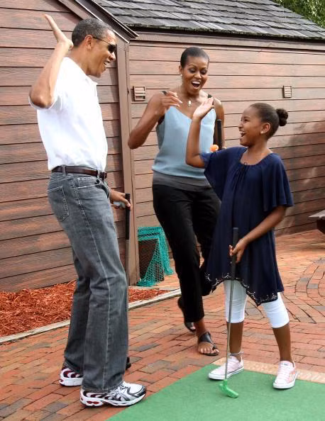 Ông bố Obama hướng dẫn cô con gái Sasha chơi golf.