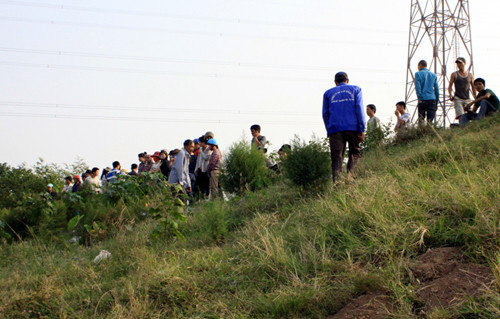 Người dân tụ tập rất đông xem xác nạn nhân, đồng thời cùng cơ quan chức năng trục vớt lên bờ.