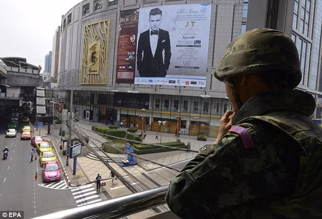 Một binh sĩ đứng bảo vệ trên cầu dành cho người đi bộ tại khu phố thương mại ở Bangkok.