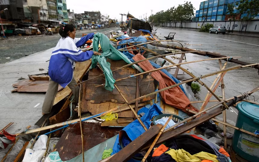 Một người dân thu dọn ngôi nhà tạm bị gió bão tàn phá ở ngoại ô Navotas.