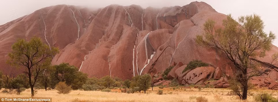 Những dòng nước trắng xóa bao phủ núi Uluru đá ở Alice Springs, Australia, sau một số trận mưa.