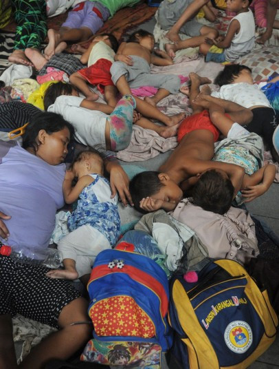 Phụ nữ và trẻ em ngủ tại một trung tâm sơ tán ở Manila.