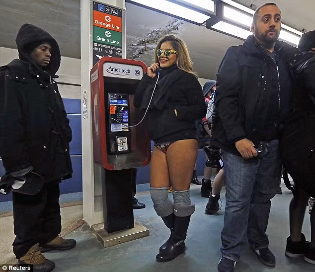 Một hành khách nữ cởi bỏ quần dài trong khi gọi điện thoại ở Chicago, Illinois, Mỹ.