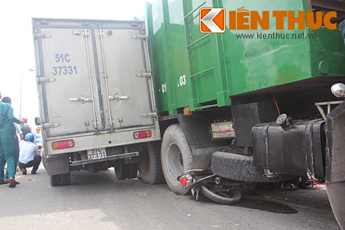 Chiếc xe tải bị xe rác máng vào bên hông, dính chặt.